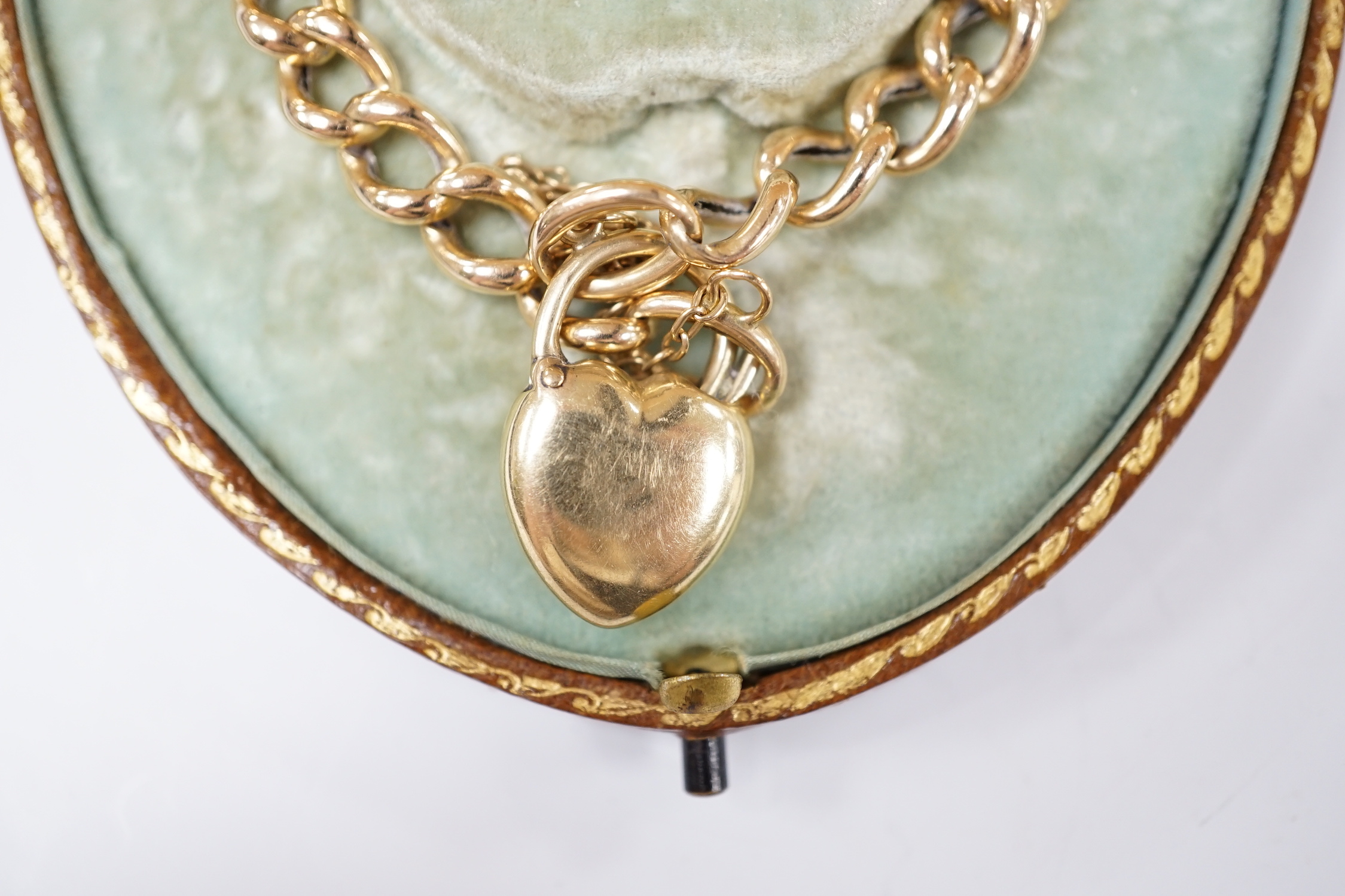 An Edwardian 15ct curblink bracelet, with sapphire set heart shaped padlock clasp, 18cm, with spare links, gross weight 13.6 grams.
